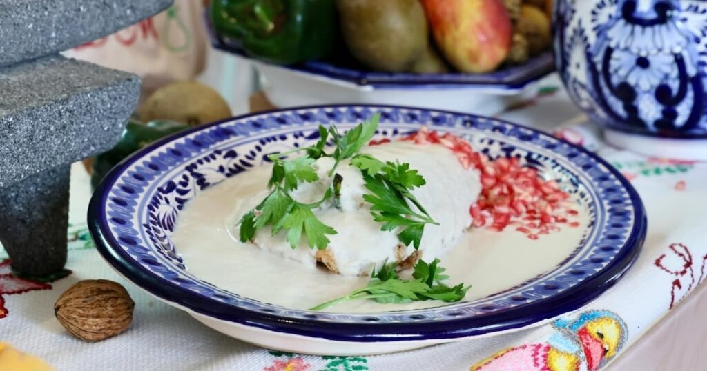 Platillo de chile en nogada con salsa de nuez y granada, representativo de la gastronomía tradicional de Puebla