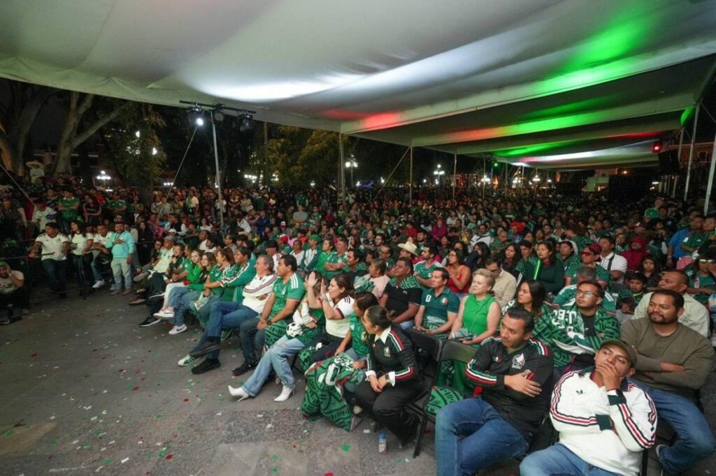 Miles de aficionados reunidos en el Zócalo de Puebla viendo partidos del Mundial 2026 en pantallas gigantes