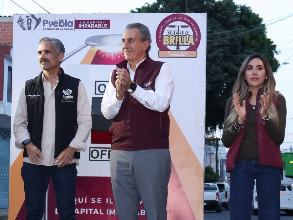 Trabajadores municipales instalando luminarias LED en postes de alumbrado público en la colonia Granjas del Sur de Puebla