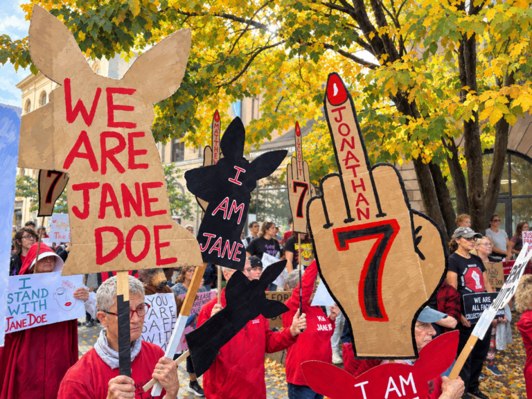 Protestan en Cornell por denuncia de agresión sexual y exigen la renuncia de su presidente Manifestantes vestidos de rojo durante una protesta en apoyo a Jane Doe frente a la Universidad de Cornell.